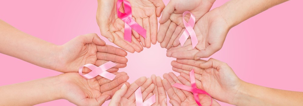 Women Hands With Cancer Awareness Ribbons Over Pink Background 1000x350